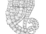 un gros plan d'une broche en diamant sur fond blanc