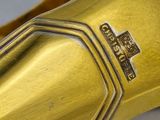 a close up view of a gold plated cuff bracelet with a cross on it