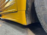 a close up of a yellow bus with a tire on the road