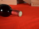 a bottle of wine sitting on a red table cloth