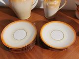 many plates and cups sitting on a table with a pitcher
