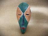 a mask on the wall that is made of wood