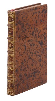 un vieux livre à la couverture brune posé sur une surface blanche