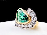 an image of a ring with a heart shaped green stone