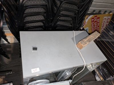 de nombreuses chaises et une table sur laquelle est posé un ordinateur