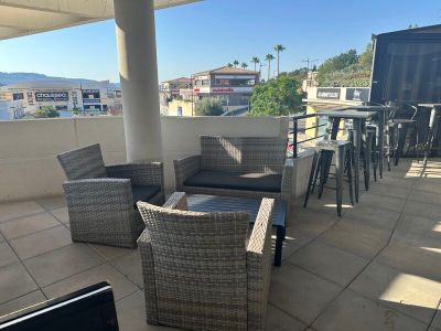 une terrasse avec des chaises en osier et une table