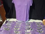 une présentation de t-shirts violets sur une table dans un magasin
