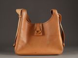 a close up of a brown purse on a gray surface