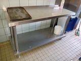 a stainless steel work table with a pan on top of it