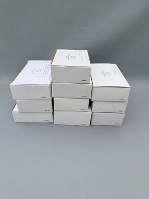 six boîtes blanches empilées les unes sur les autres sur une surface grise