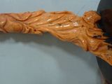 a wooden carving of a woman on a black plate