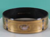 an image of a black and gold bracelet on a white surface