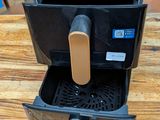 a black coffee maker sitting on a wooden table