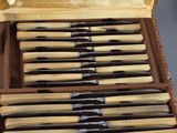 eight knives in a case that are sitting on a table