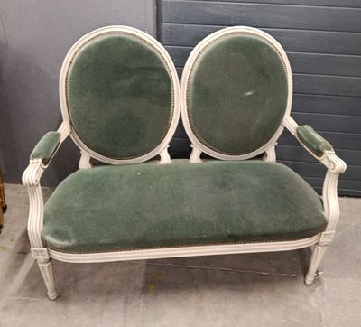 a green and white couch with two chairs on it