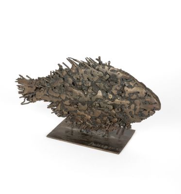 une photo d'une sculpture représentant un poisson posée sur un socle en bois