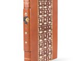 un vieux livre à la couverture brune posé sur une surface blanche