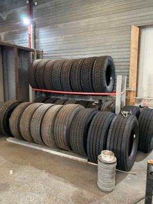 de nombreux pneus empilés sur un support dans un garage