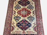 an antique persian rug with a blue, red, and white design