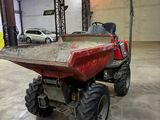 a red truck with a big wheel on it in a garage