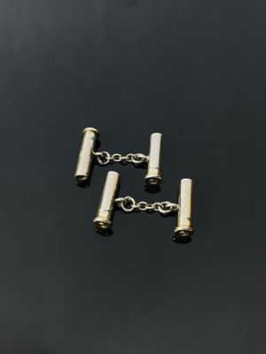 a close up of a pair of silver cufflinks on a black surface