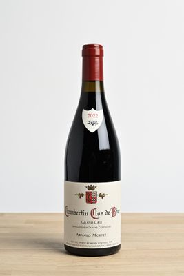 la bouteille de vin rouge est posée sur une table en bois