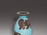 a blue vase with brown designs on it on a white surface