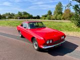 une voiture rouge garée sur le bord de la route