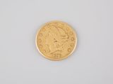 a close up of a gold coin on a white surface