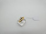 gros plan d'une bague sur une surface blanche avec une étiquette de prix