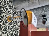 une lampe jaune fixée au mur, à côté d'un mur noir et blanc