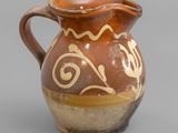 un vase marron et blanc posé sur une surface grise
