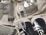 four pairs of baby shoes that are in a bag