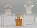 two bottles of perfume sitting next to each other on a table