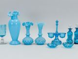 a lot of blue glass vases and wine glasses on the table