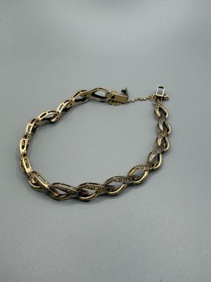 gros plan d'un bracelet en chaîne en or sur une table