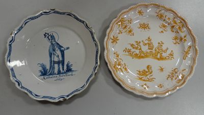 two plates with blue and yellow designs on them sitting on a table