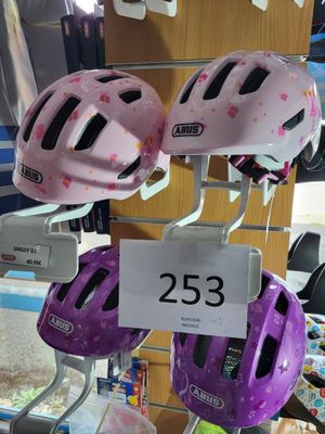 plusieurs casques en vente dans un magasin, avec leurs étiquettes de prix
