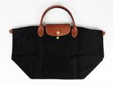 un sac Longchamp noir et marron sur fond blanc