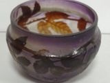 a purple bowl with a design of leaves on it