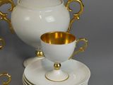 a white and gold tea set with cups and saucers