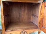 a wooden cabinet with a door open on a tile floor