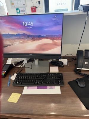 a desk with a computer, keyboard, mouse and other items on it