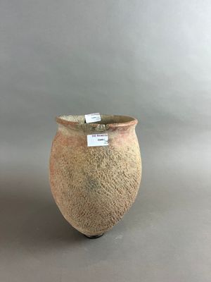 un petit vase muni d'une étiquette, posé sur une table