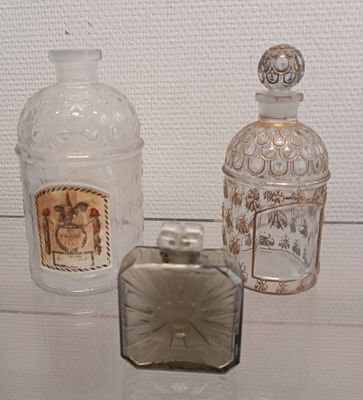three glass bottles and a lighter sitting on a table