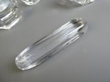 un objet en verre transparent posé sur une table à côté d'autres objets en verre