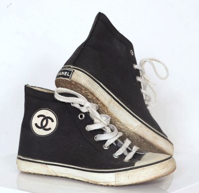 une paire de baskets noires et blanches portant le logo de Chanel