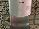 a water dispenser on a tiled wall in a bathroom