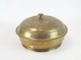 an antique brass covered dish with a lid on a white surface
