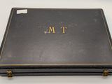 an old black box with a gold monogram on it